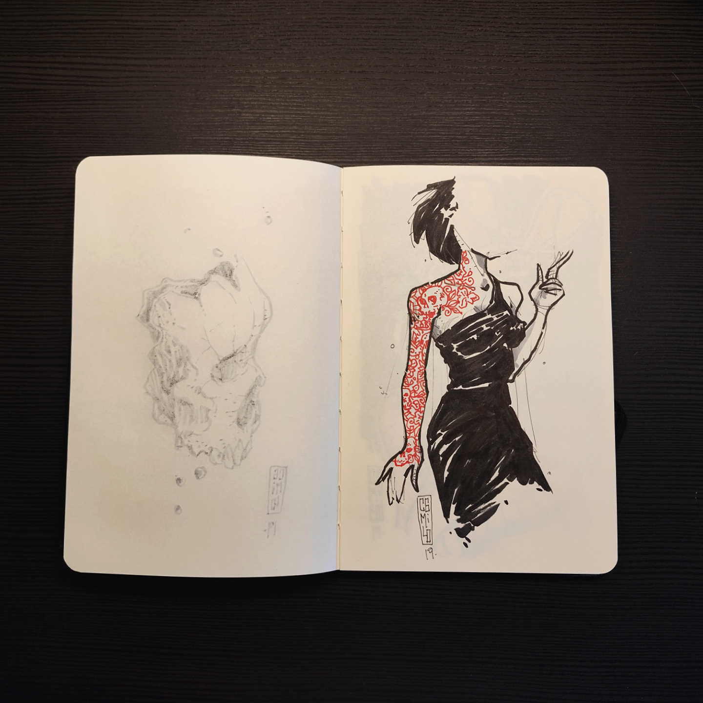 tattooed vampire in a black dress, with red tattoos on her arm and shoulder