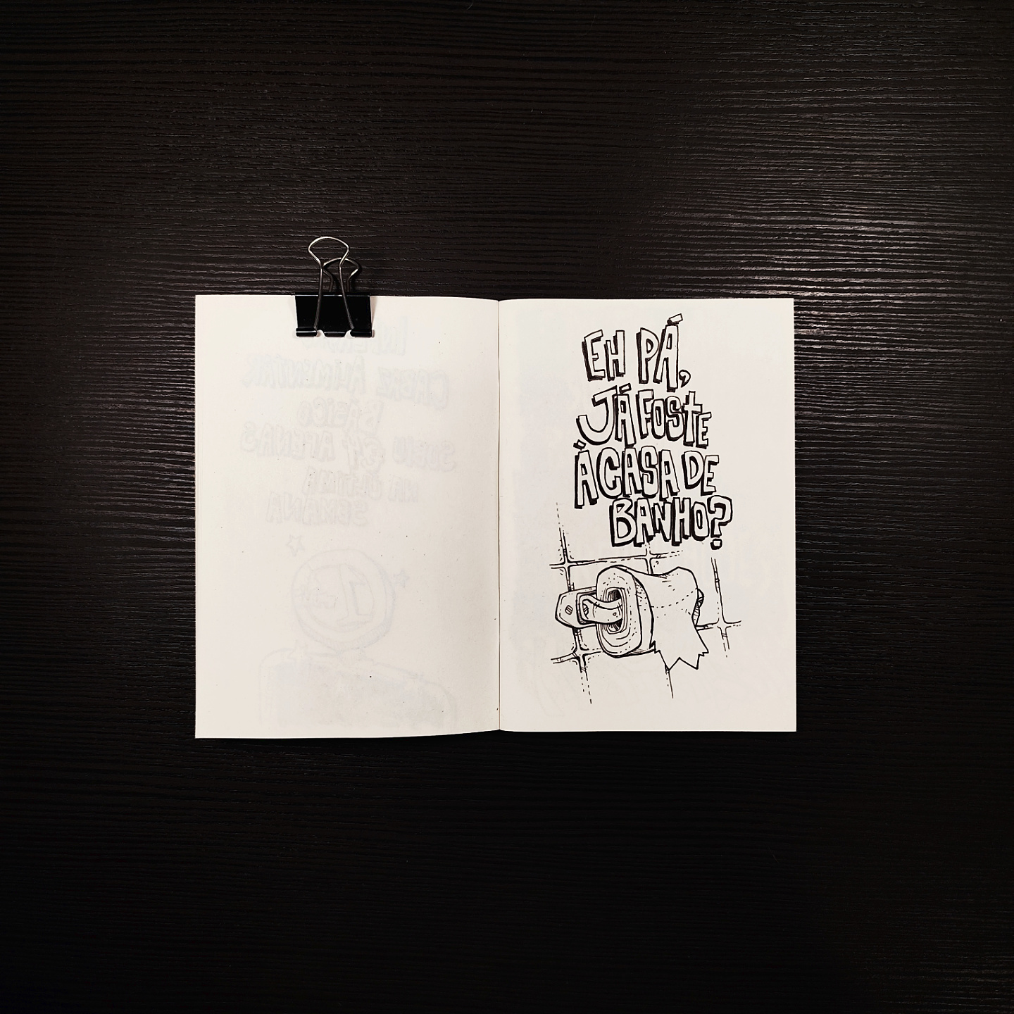 sketchbook page for Casa de Banho in Ink, hand lettered with Eh Pá Já Foste à Casa de Banho above an inked drawing of a toilet paper holder on a tiled wall